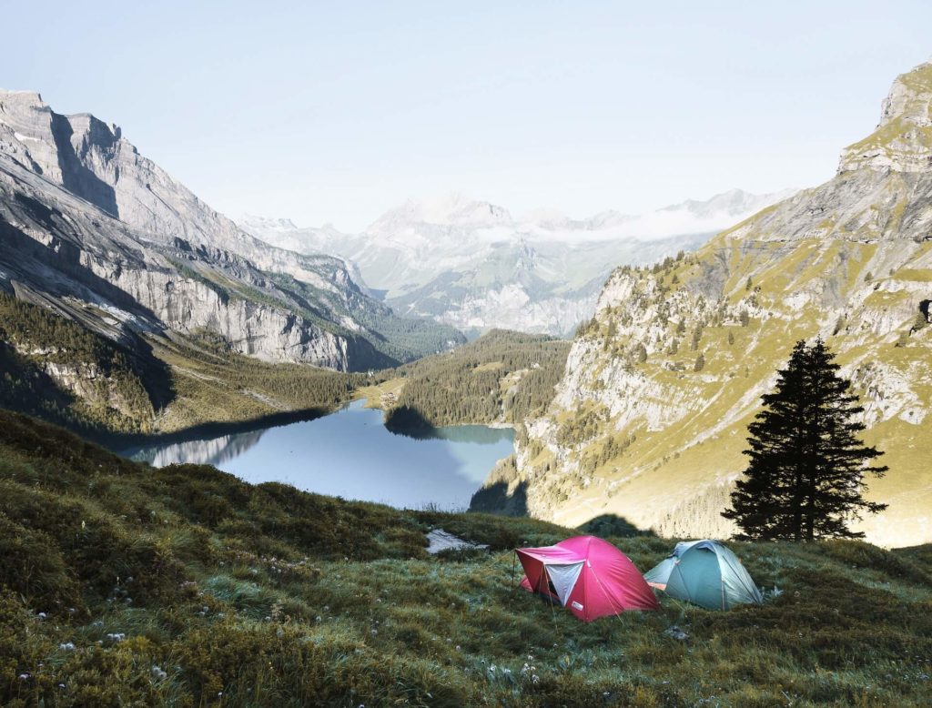 tents in a valley with a lake