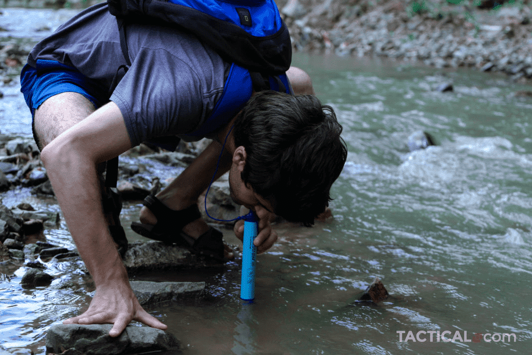 using a Lifestraw to drink water directly from a water source