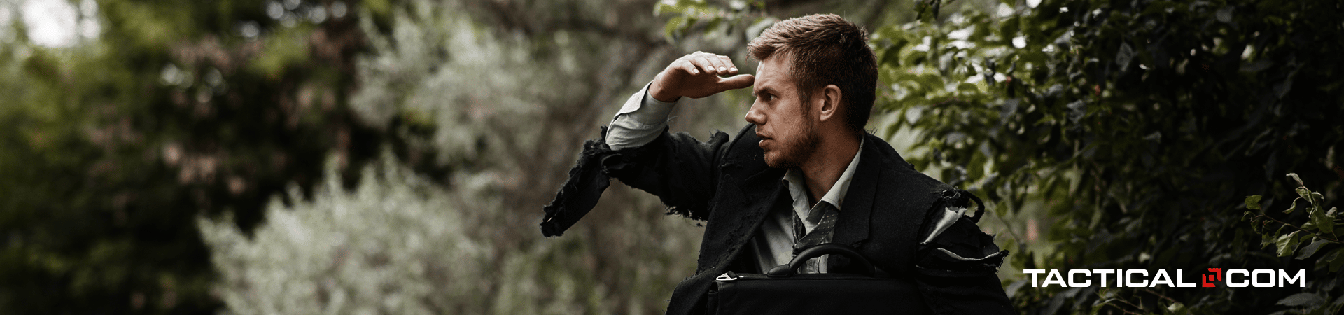 man in a suit outdoors; looking at something