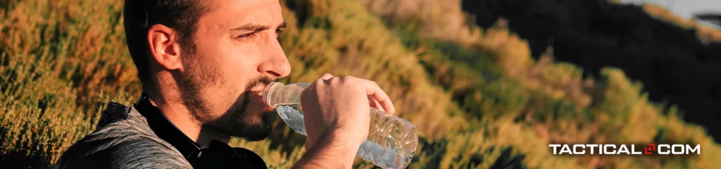 man drinking a bottle of water outdoors